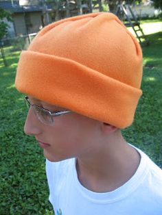 a young man wearing an orange hat and glasses