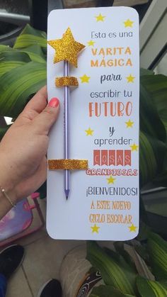 a person holding up a card with writing on it and a pen sticking out of it