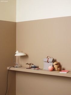 a room with a shelf and lamp on the wall next to other items that have been placed on it