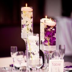 an image of a table setting with candles and flowers in vases on the table