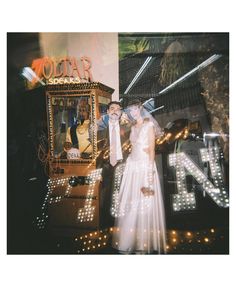 a man and woman are standing in front of a marquee