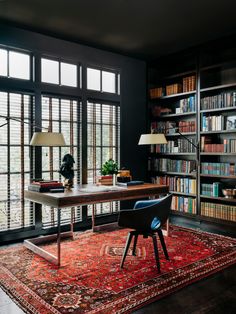 a room with lots of bookshelves and a rug on the floor in front of it