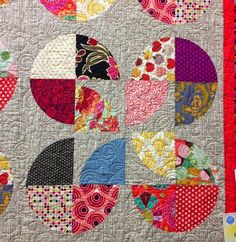 a close up of a quilt with many different designs on it, including circles and dots