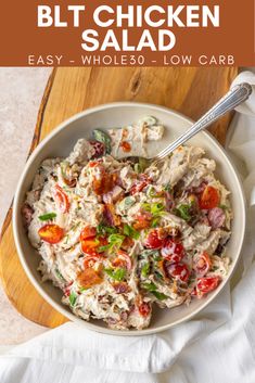 a white bowl filled with chicken salad on top of a wooden cutting board