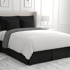 a bed with black and white sheets in a room