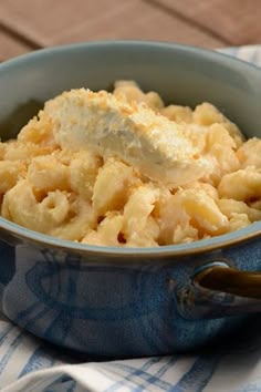 a bowl filled with macaroni and cheese on top of a blue dish towel