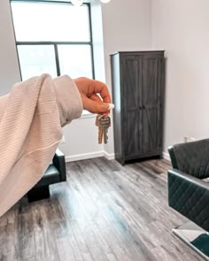 a person is holding keys in their living room