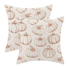 two pillows with pumpkins on them, one is white and the other is brown