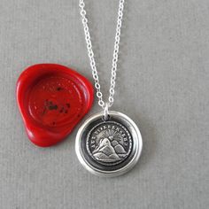 "Wax seal necklace depicting a sun setting behind hills, and motto \"Until We Meet Again\". Antique wax seal charm jewelry made in silver. This listing is for one necklace with setting sun. The words framing this piece reads in German: Auf Wiedersehn (Until We Meet Again) As surely as the sun rises, I will return. The antique wax seal used in creating this charm dates back to the beginning of the 1800's, it originates from France.  Note:  * size of charm is about 13mm across  * this listing is for one charm and an 18 inch delicate sterling silver chain The wax seal charm necklaces are made by hand in Myrtle Beach, SC by RQP Studio. The charm is made of fine silver .999 (which is 99.9% pure silver), and a 18\" sterling silver chain is included (sterling silver is 92.5% pure silver). Please Wax Letter Seal, Scissor Necklace, Wax Seal Pendant, Seal Necklace, Wax Seal Jewelry, Wax Seal Necklace, Until We Meet Again, The Sun Rises, Antique Wax