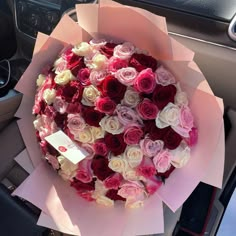 a bouquet of roses is sitting on the dashboard of a car, ready to be delivered