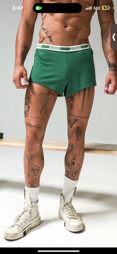 a man in green shorts with tattoos on his legs