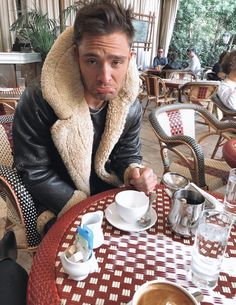 a man sitting at a table with coffee in front of him