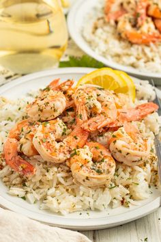 shrimp and rice on a plate with lemon wedges