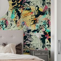 a bed sitting under a painting on the wall next to a nightstand with a lamp