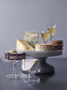 cheese and crackers on a platter with wine glasses