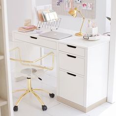 a white desk topped with a laptop computer sitting on top of a wooden table next to a chair