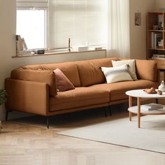 a living room with a couch, coffee table and bookshelf in the corner