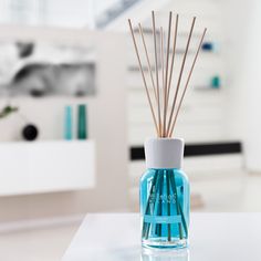 a blue bottle with reeds in it sitting on a table