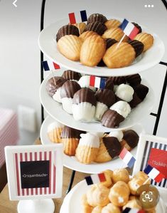 three tiered plates filled with desserts on top of a table