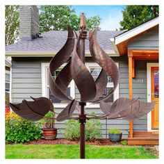 a metal sculpture in front of a house