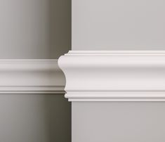 the corner of a wall with white molding on it's sides and an empty shelf below