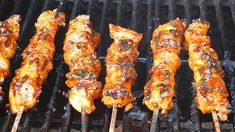 several skewers of food cooking on a grill