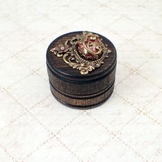 a small wooden box sitting on top of a white table covered in intricately designed designs