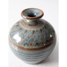 a blue and brown vase sitting on top of a table