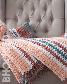 a crocheted blanket sitting on top of a couch next to a gray chair