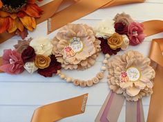 three flower hair clips with ribbons around them