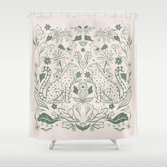 a green and white shower curtain with an animal design on the front, and flowers in the back