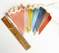 there is a ruler next to several different colored pennants