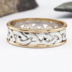 two tone gold and silver wedding band with interlocked links on each side, set against a white background