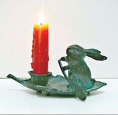 a candle that is sitting next to a rabbit figurine