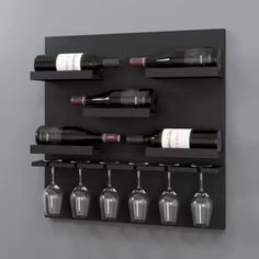 a wall mounted wine rack with six bottles and glasses