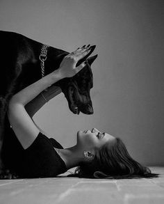 a woman is laying on the floor with her dog and looking up at something in front of her