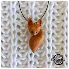 a small wooden animal on a black cord necklace