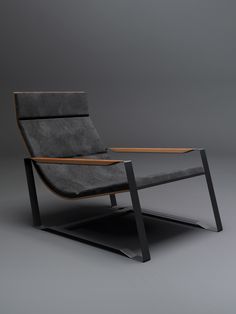 a gray chair with a wooden table on it's back end, sitting in front of a grey background