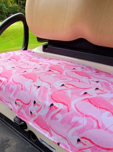 the back end of a golf cart with pink flamingos on it's seat