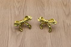 pair of gold bowknots on wooden surface