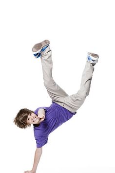 a young man is doing a handstand on one leg with his feet in the air