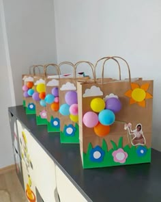 some paper bags with balloons on them sitting on a table