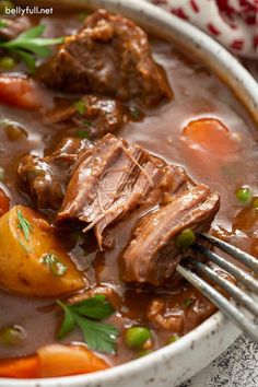 a white bowl filled with beef and potatoes