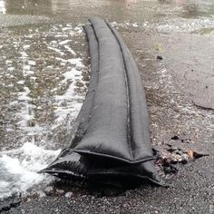 a black tire laying on the ground next to water