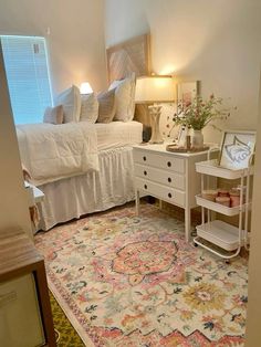 a bedroom with a bed, dresser and rug on the floor in front of it