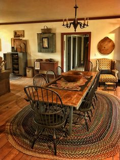 a dining room table with chairs and a rug on the floor