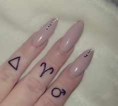 two fingers with tattoos on them, one has an arrow and the other has numbers