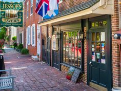 the outside of a restaurant with flags hanging from it's windows and brick buildings