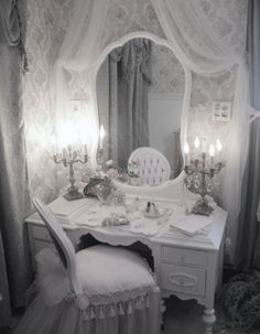 an old fashioned dressing table with candles on it and a mirror in the corner above it