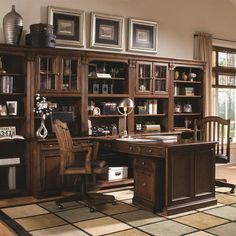 a large wooden desk sitting in front of a book shelf filled with lots of books